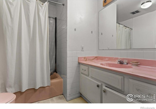 full bathroom with vanity, shower / tub combo, decorative backsplash, tile walls, and toilet