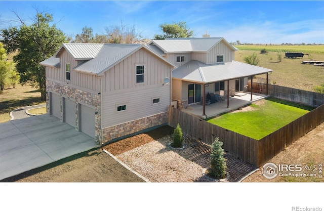 back of house featuring a yard, covered porch, and a garage