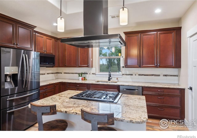 kitchen with a kitchen breakfast bar, stainless steel appliances, island range hood, and decorative light fixtures