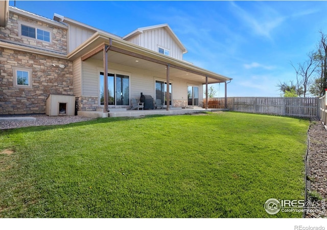 back of house with a yard and a patio