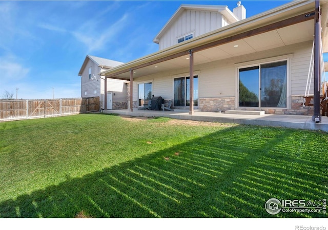 rear view of property with a lawn and a patio area