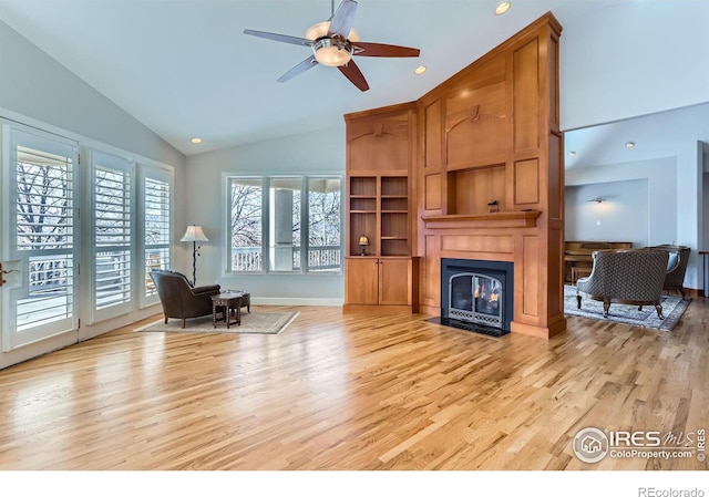 living room featuring ceiling fan, high vaulted ceiling, and light hardwood / wood-style flooring