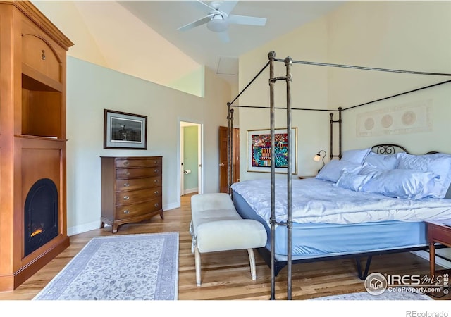 bedroom featuring high vaulted ceiling and light hardwood / wood-style floors