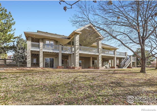 view of front facade with a balcony and a front lawn