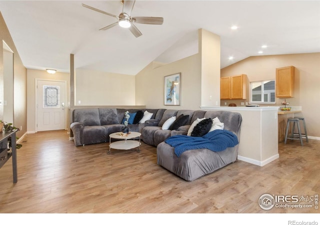 living room with lofted ceiling, ceiling fan, and light hardwood / wood-style flooring