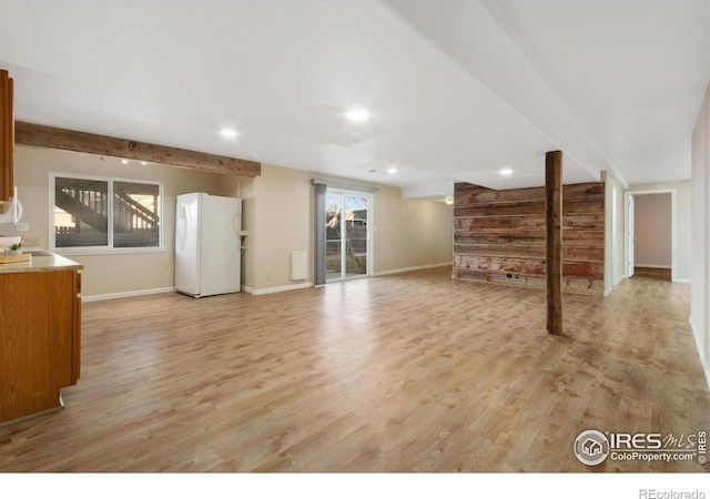 unfurnished living room featuring sink and light hardwood / wood-style floors