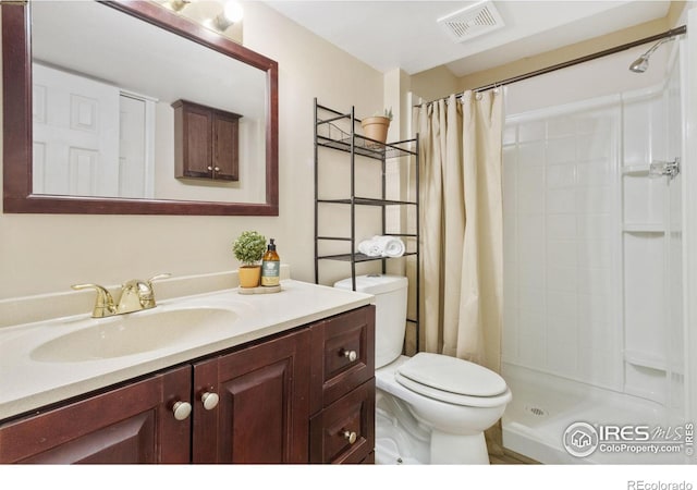 bathroom with toilet, a shower with shower curtain, and vanity