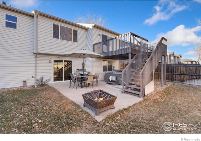 back of house featuring a patio area, a deck, and a fire pit