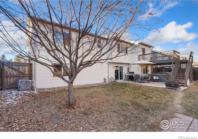 back of property featuring a hot tub, a patio area, a yard, a deck, and central air condition unit