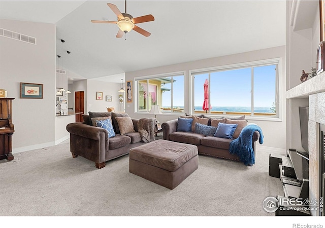 carpeted living room featuring high vaulted ceiling, ceiling fan, a water view, and a fireplace