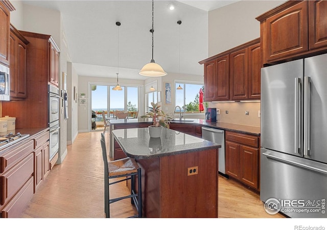 kitchen featuring appliances with stainless steel finishes, plenty of natural light, pendant lighting, and a kitchen island