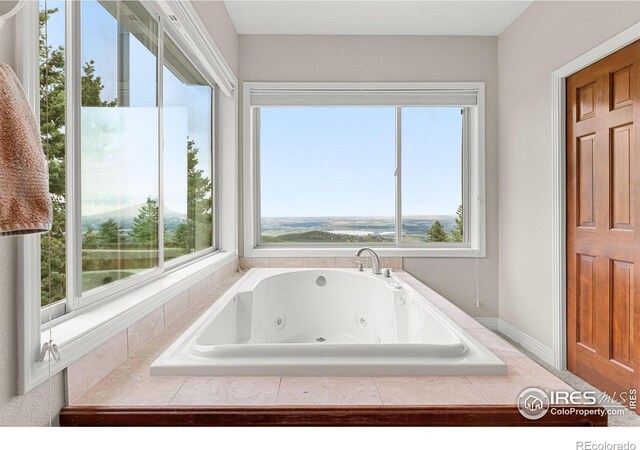 bathroom with a wealth of natural light and a relaxing tiled tub