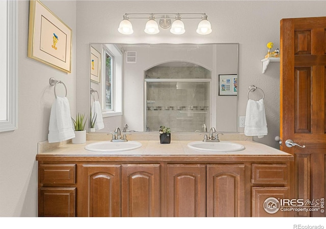 bathroom featuring an enclosed shower and vanity