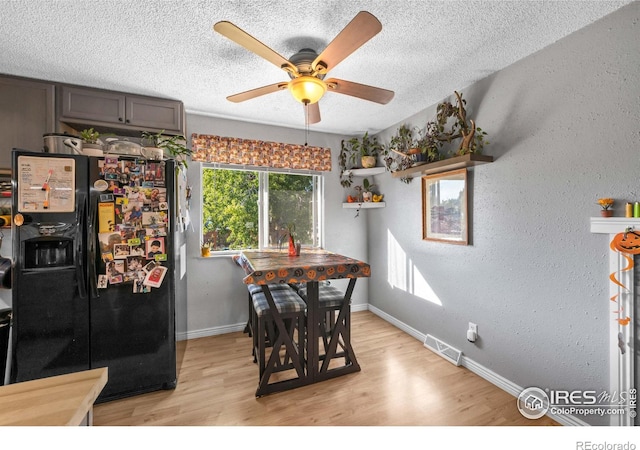 dining room featuring ceiling fan, a textured ceiling, and light hardwood / wood-style flooring