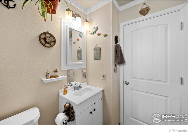 bathroom featuring vanity, ornamental molding, and toilet