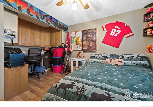 bedroom featuring ceiling fan, a textured ceiling, and light wood-type flooring