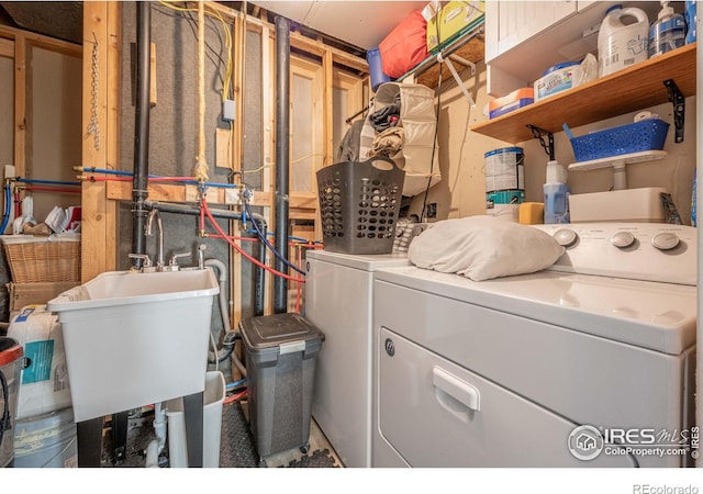 clothes washing area with sink and washer and clothes dryer