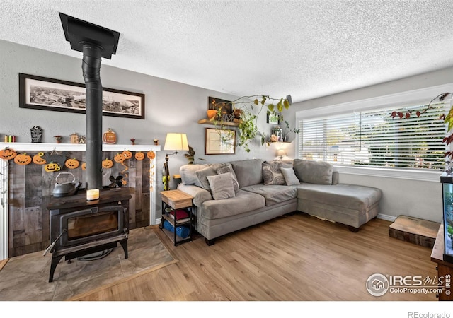 living room with hardwood / wood-style floors, a textured ceiling, and a wood stove