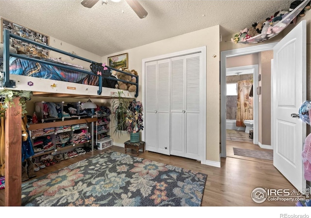 bedroom featuring hardwood / wood-style flooring, ceiling fan, a textured ceiling, and a closet