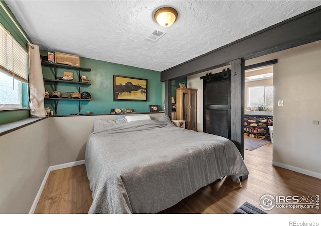 bedroom featuring hardwood / wood-style flooring and a textured ceiling