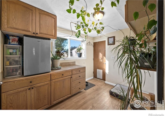 kitchen featuring a textured ceiling and light wood-type flooring