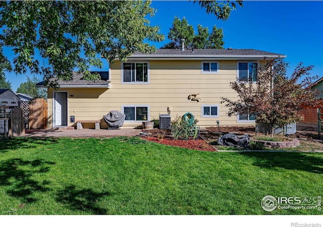 rear view of property with a yard, central AC unit, and a patio