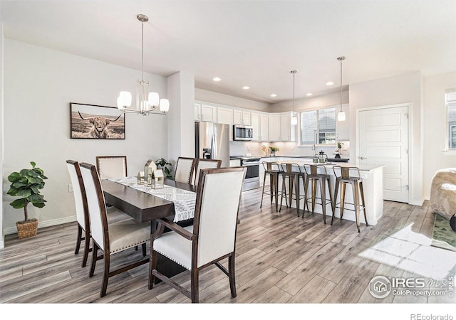 dining area with a chandelier and light hardwood / wood-style floors