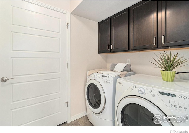 laundry room featuring washing machine and clothes dryer and cabinets