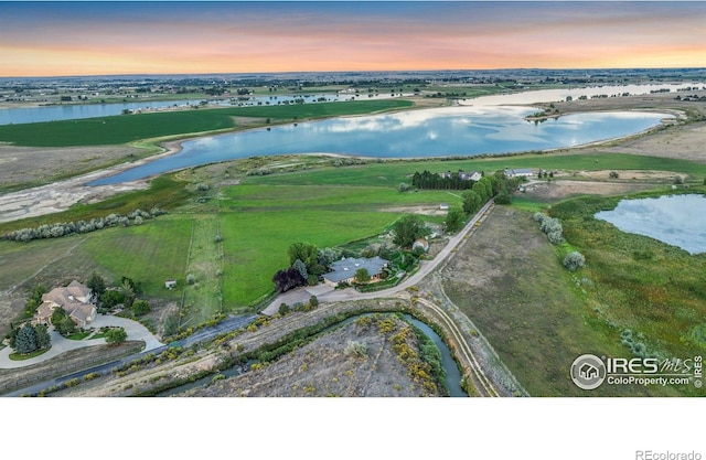 aerial view at dusk featuring a water view