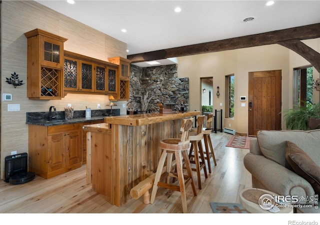 kitchen with a wealth of natural light, sink, beamed ceiling, and light hardwood / wood-style flooring