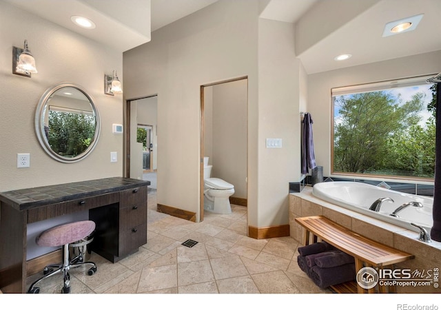 bathroom with tiled bath, toilet, and tile patterned flooring