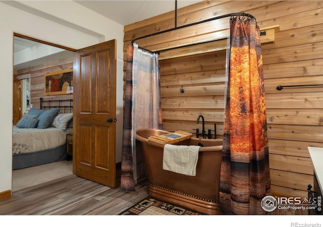 bathroom featuring wooden walls and hardwood / wood-style floors