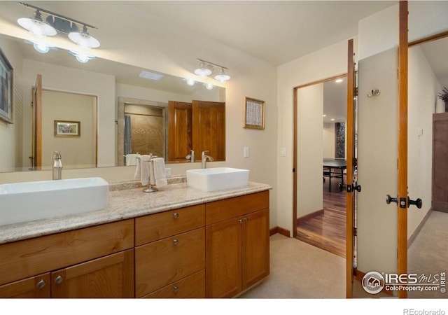 bathroom featuring walk in shower and vanity