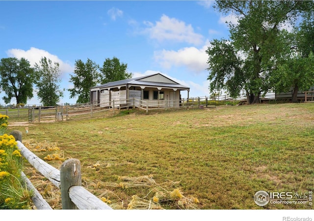 view of yard featuring a rural view and an outbuilding