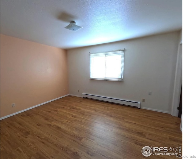 unfurnished room featuring dark wood-type flooring and a baseboard radiator