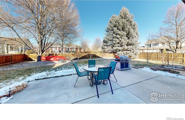 snow covered patio featuring a grill