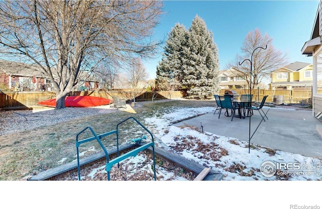 yard layered in snow featuring a patio