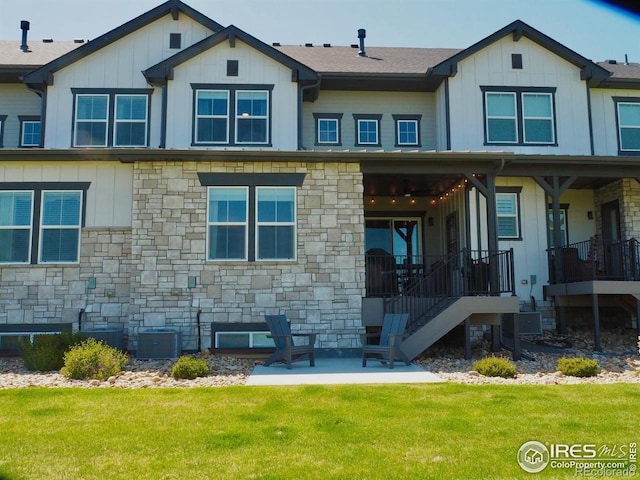 4260 Grand Park Dr, Timnath, CO 80547 - back of house featuring stone siding, a lawn, and board and batten siding