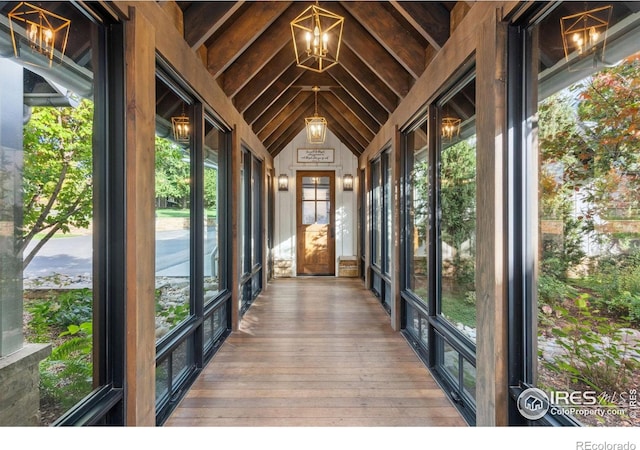 unfurnished sunroom featuring lofted ceiling and a notable chandelier