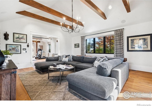 living room featuring baseboards, beam ceiling, an inviting chandelier, and wood finished floors