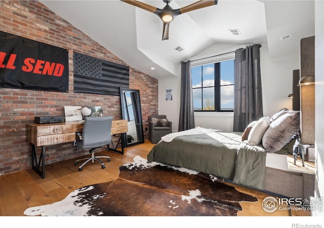 bedroom with visible vents, brick wall, wood-type flooring, and vaulted ceiling