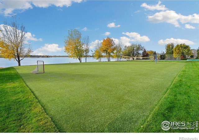 view of home's community featuring volleyball court, a yard, and a water view