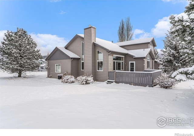 view of snow covered back of property