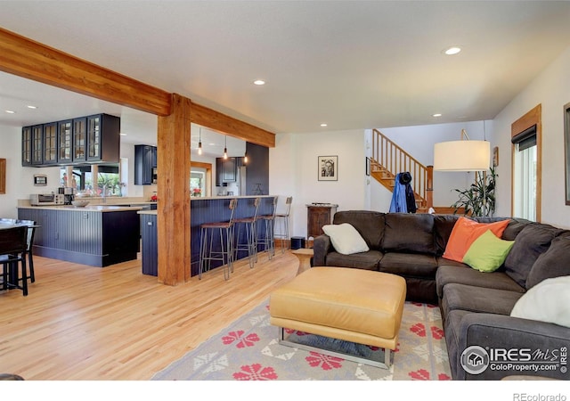 living room featuring light hardwood / wood-style flooring and beamed ceiling