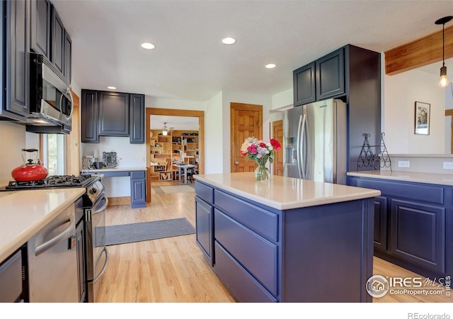 kitchen featuring pendant lighting, a center island, beamed ceiling, stainless steel appliances, and blue cabinets