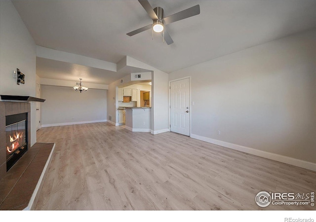 770 Copper Ln Unit 206, Louisville, CO 80027 - unfurnished living room featuring vaulted ceiling, a fireplace, ceiling fan with notable chandelier, and light hardwood / wood-style floors