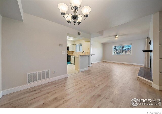 770 Copper Ln Unit 206, Louisville, CO 80027 - unfurnished living room featuring ceiling fan with notable chandelier, sink, and light hardwood / wood-style flooring