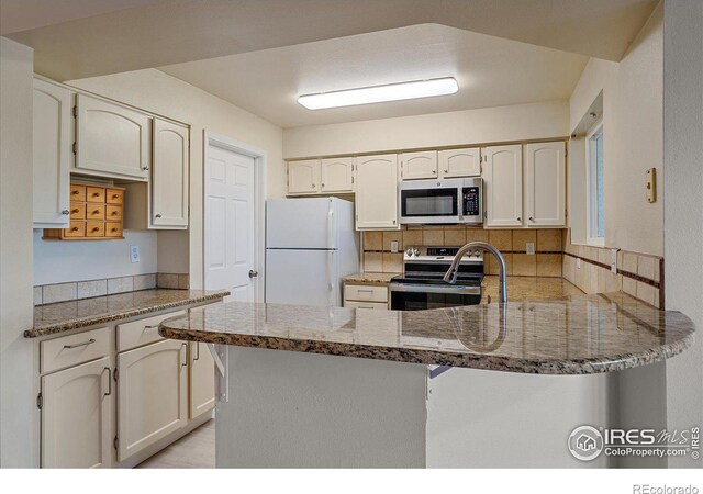 770 Copper Ln Unit 206, Louisville, CO 80027 - kitchen with kitchen peninsula, appliances with stainless steel finishes, decorative backsplash, and white cabinetry