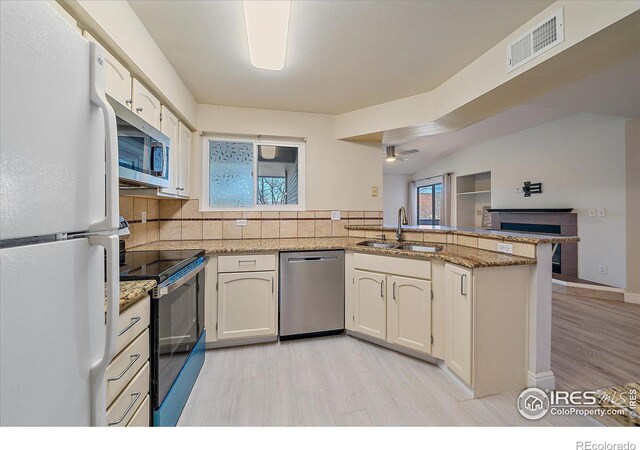 770 Copper Ln Unit 206, Louisville, CO 80027 - kitchen with ceiling fan, backsplash, kitchen peninsula, sink, and appliances with stainless steel finishes