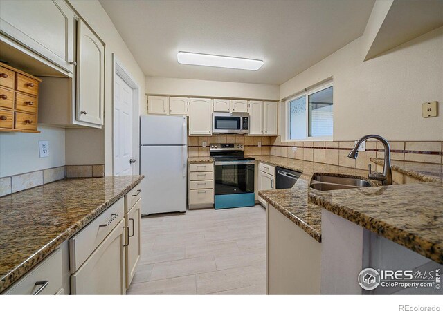 770 Copper Ln Unit 206, Louisville, CO 80027 - kitchen with white cabinets, dark stone counters, sink, and stainless steel appliances